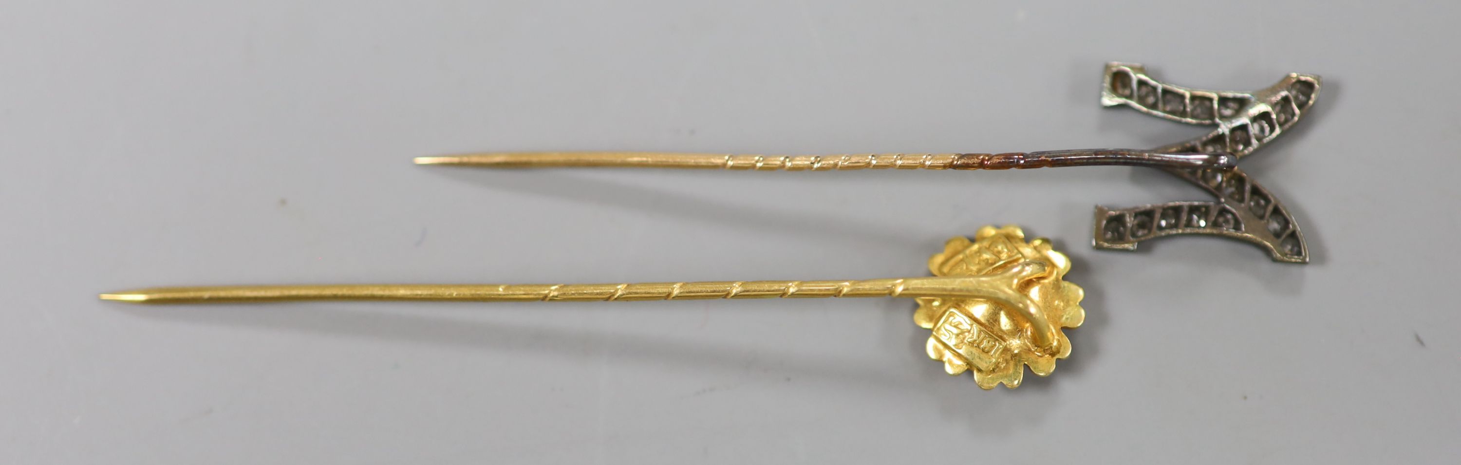 An early 20th century yellow metal and rose cut diamond set M stick pin, 58mm, gross 1.8 grams & 1 other stick pin.